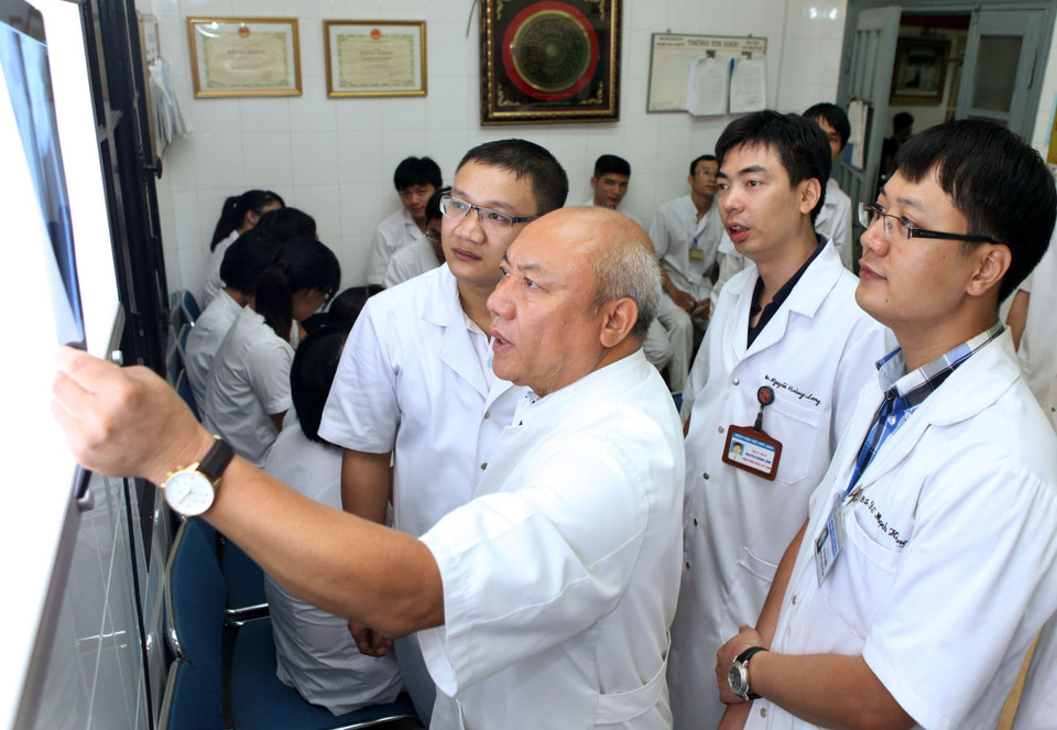 PGS.TS. Thầy thuốc nhân dân Nguyễn Văn Thạch, Phó Giám đốc Bệnh viện Việt Đức, có nhiều thành công trong các lĩnh vực điều trị thoát vị đĩa đệm cột sống bằng sóng cao tần, bằng phẫu thuật nội soi qua lỗ liên hợp, bằng lấy thoát vị qua da, ứng dụng robot định vị chính xác trong phẫu thuật cột sống… Trong ảnh: Bác sỹ Nguyễn Văn Thạch (giữa) hội chẩn cùng các bác sỹ tại Viện Chấn thương chỉnh hình - Bệnh viện Việt Đức. (Ảnh: Lâm Khánh/TTXVN)