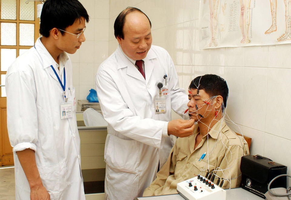 Thầy thuốc ưu tú, tiến sỹ y học Nghiêm Hữu Thành, Giám đốc Bệnh viện Châm cứu Trung ương, có hàng chục công trình nghiên cứu khoa học phục vụ điều trị hiệu quả cho người bệnh. Trong ảnh: Tiến sỹ Nghiêm Hữu Thành kiểm tra kết quả điều trị cho người bệnh. (Ảnh: Hữu Oai/TTXVN)