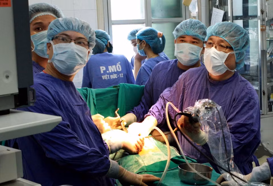 Phó giáo sư, tiến sỹ, anh hùng lao động, thầy thuốc nhân dân Nguyễn Tiến Quyết, Giám đốc Bệnh viện Hữu nghị Việt Đức (Bộ Y tế), là người đi đầu thực hiện thành công ca ghép gan từ người sống, người chết não - một trong những thành tựu y học xuất sắc của ngành Y tế Việt Nam. Gần 40 năm gắn bó với nghề, ông đã nỗ lực phấn đấu không mệt mỏi, nghiên cứu, tìm tòi, say mê với công việc đầy nhọc nhằn và vinh quang. Trong ảnh: GS.TS Nguyễn Tiến Quyết (bên phải) cùng kíp mổ thực hiện lấy sỏi đường mật gan bằng kỹ thuật nội soi tán sỏi để bảo tồn gan cho người bệnh. (Ảnh: Dương Ngọc/TTXVN)