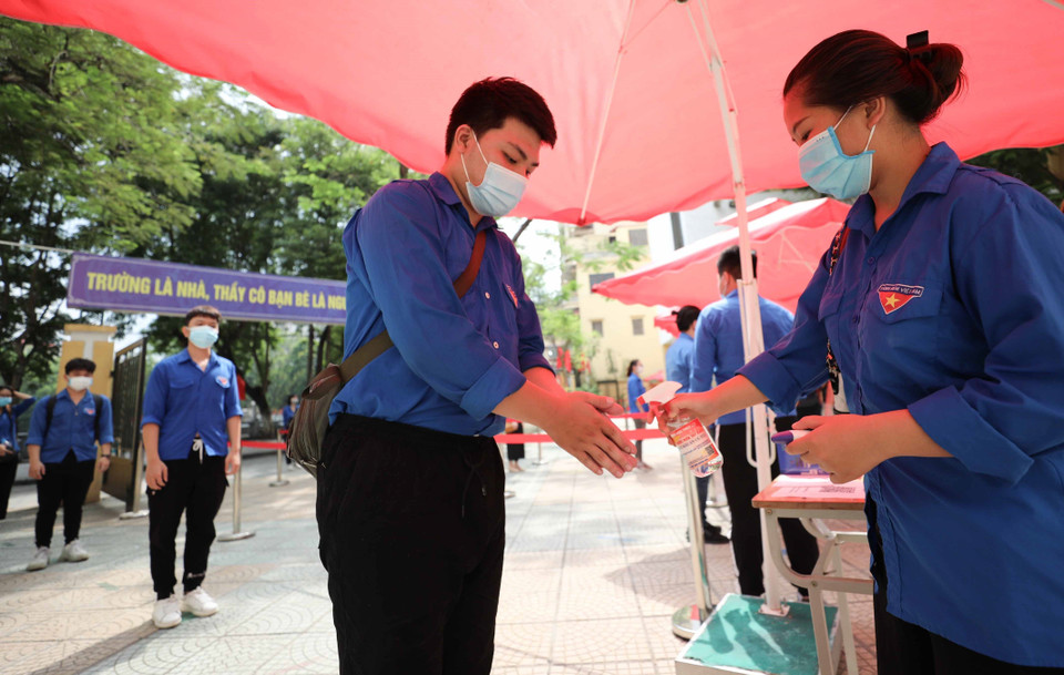 Phân luồng thí sinh, đo thân nhiệt, sát khuẩn tay bảo đảm giãn cách tại điểm thi Trường THPT Trần Nhân Tông (quận Hai Bà Trưng). (Ảnh: Thanh Tùng/TTXVN)