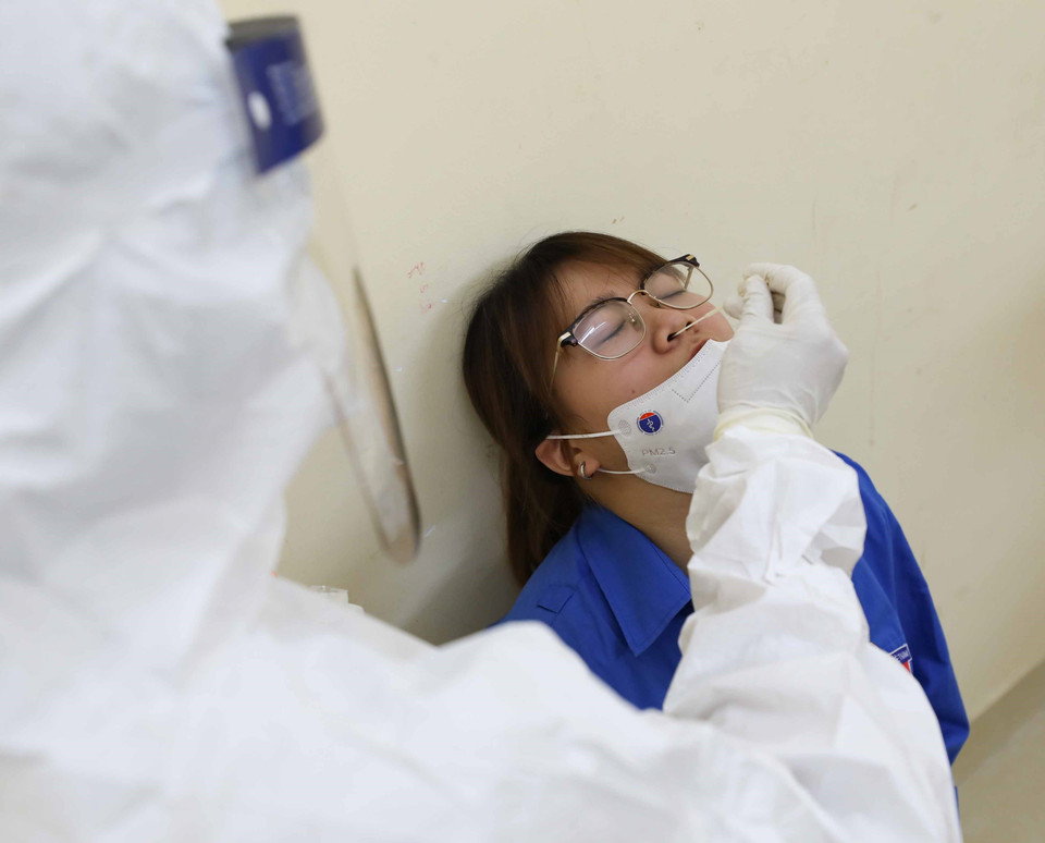 Đội phản ứng nhanh tiến hành điều tra dịch tễ, lấy mẫu xét nghiệm, để thí sinh mặc đồ phòng hộ và đưa tới cơ sở y tế. (Ảnh: Thanh Tùng/TTXVN)