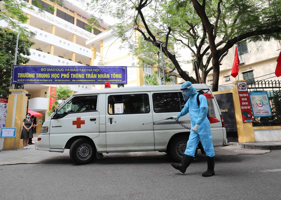 Phun khử khuẩn xe cứu thương đưa thí sinh tới cơ sở y tế. (Ảnh: Thanh Tùng/TTXVN)