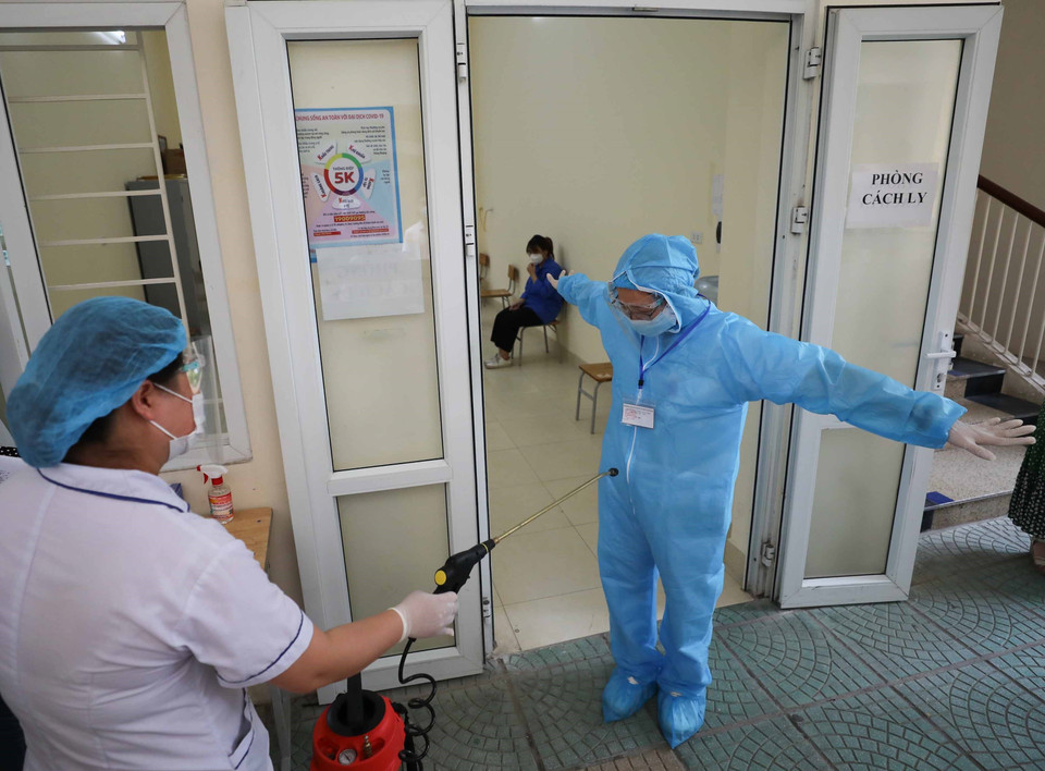 Phun khử khuẩn sau khi nhân viên y tế tiếp xúc với thí sinh có biểu hiện ho, sốt. (Ảnh: Thanh Tùng/TTXVN)