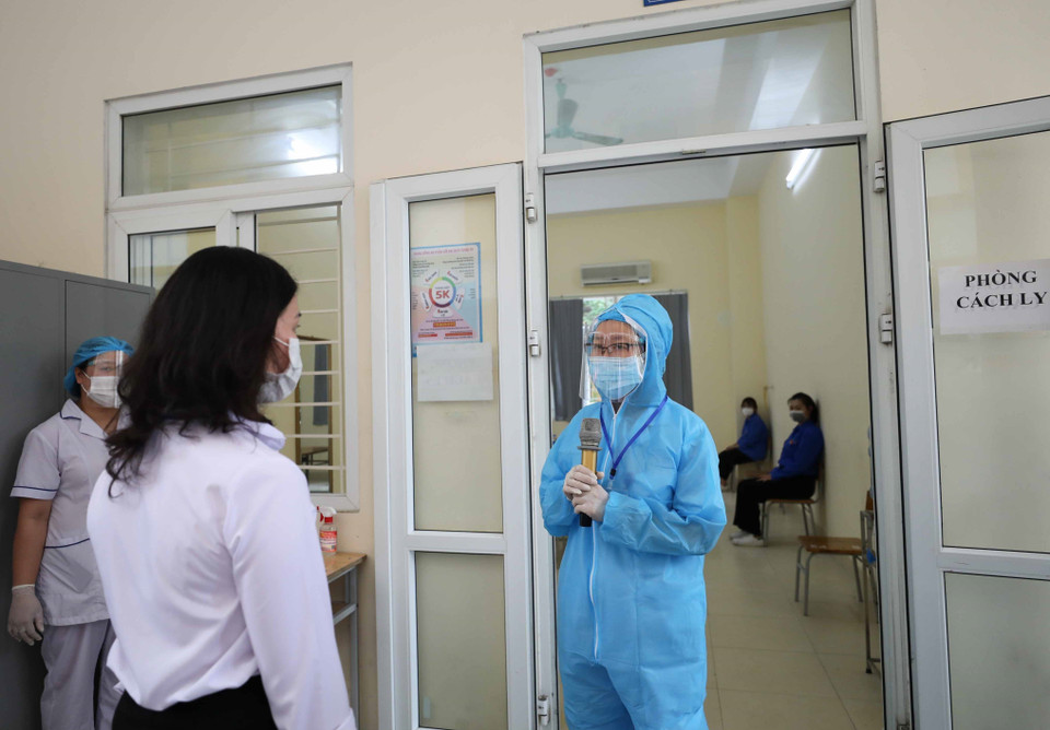 Cán bộ y tế báo cáo với điểm trưởng điểm thi về tình hình sức khỏe của thí sinh để đưa ra quyết định cuối cùng. (Ảnh: Thanh Tùng/TTXVN)