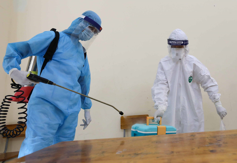 Đội phản ứng nhanh phun khử khuẩn phòng cách ly và vật dụng y tế trước khi rời khỏi để đưa thí sinh tới cơ sở y tế. (Ảnh: Thanh Tùng/TTXVN)