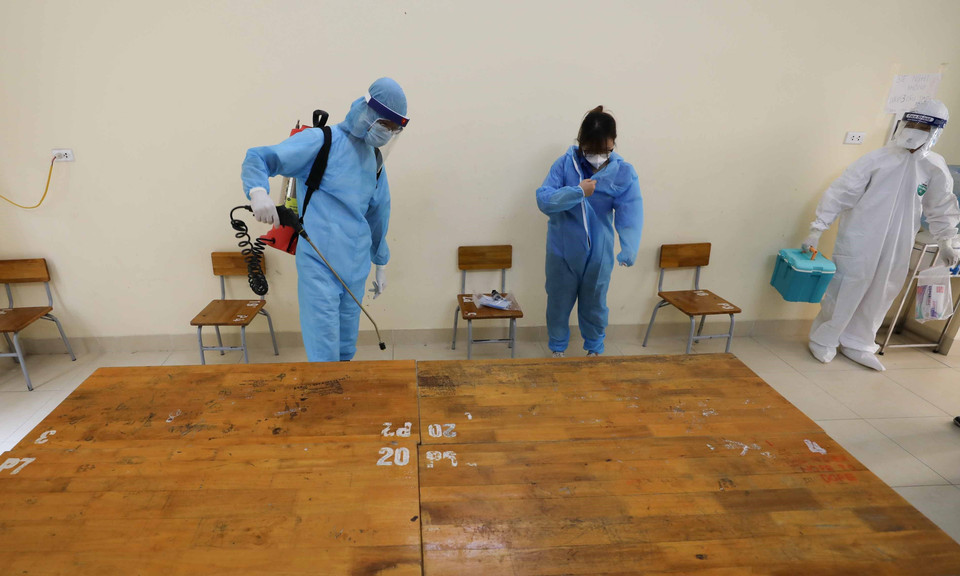 Đội phản ứng nhanh phun khử khuẩn phòng cách ly và vật dụng y tế trước khi rời khỏi để đưa thí sinh tới cơ sở y tế. (Ảnh: Thanh Tùng/TTXVN)