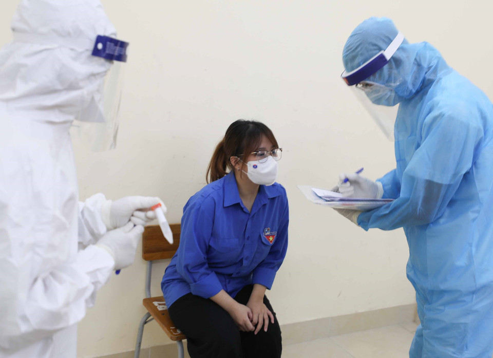 Đội phản ứng nhanh tiến hành điều tra dịch tễ, lấy mẫu xét nghiệm, để thí sinh mặc đồ phòng hộ và đưa tới cơ sở y tế. (Ảnh: Thanh Tùng/TTXVN)