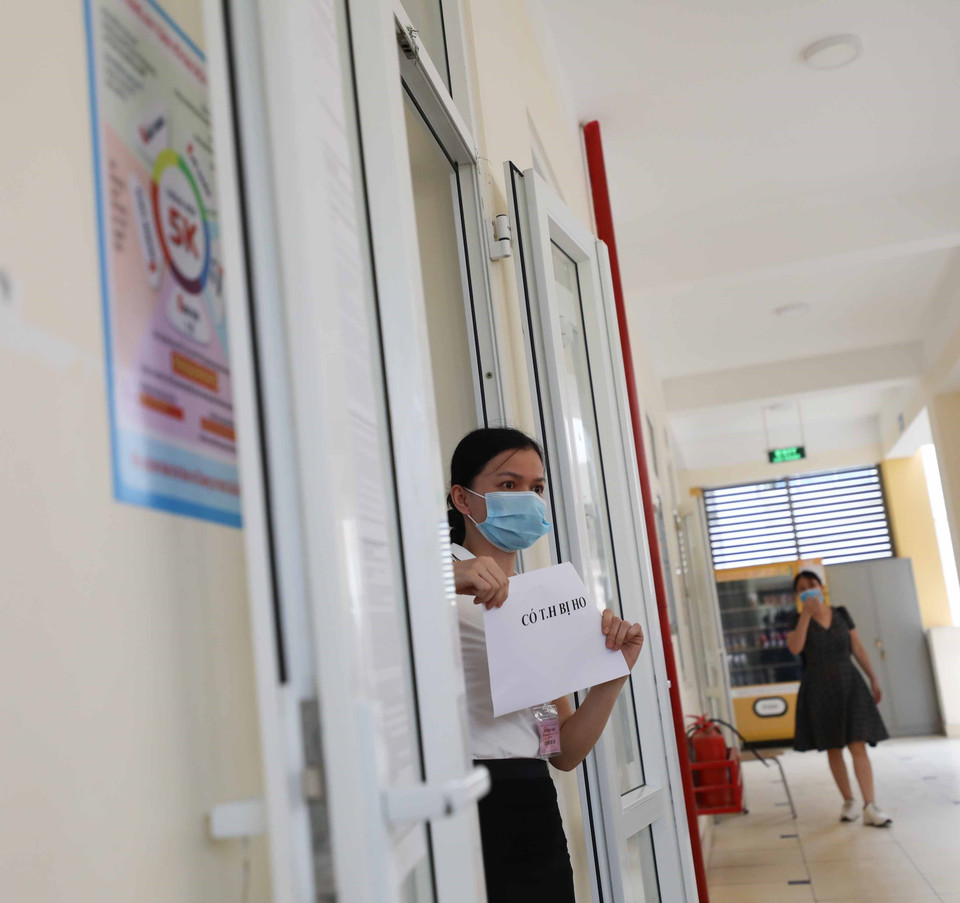 Khi phát hiện thí sinh có biểu hiện ho, sốt trong quá trình làm bài thi, giám thị báo cáo với giám sát, điểm trưởng và đưa thí sinh xuống phòng cách ly y tế.(Ảnh: Thanh Tùng/TTXVN) 