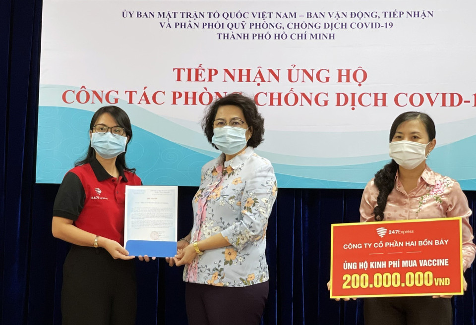 Bà Tô Thị Bích Châu, Chủ tịch Ủy ban MTTQ Việt Nam Thành phố Hồ Chí Minh (giữa) tiếp nhận kinh phí ủng hộ mua vaccine phòng, chống COVID-19 từ đại diện các doanh nghiệp, tổ chức (3/6/2021). (Ảnh: Xuân Khu/TTXVN)