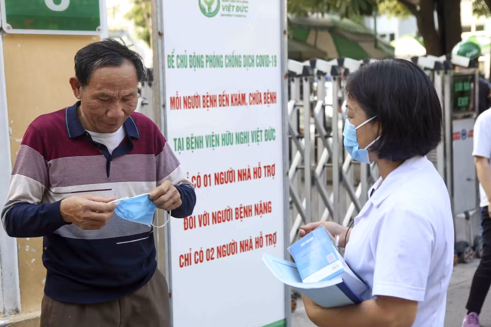 Nhân viên y tế phát khẩu trang cho một số người dân chưa tuân thủ việc đeo khẩu trang phòng, chống dịch bệnh. (Ảnh: Tuấn Đức/TTXVN)
