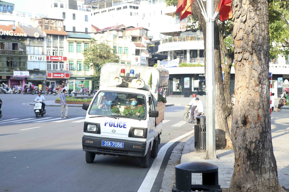 Xe của lực lượng chức năng kiểm tra, nhắc nhở những người không đeo khẩu trang dọc các tuyến phố thuộc địa bàn phường Hàng Trống. (Ảnh: Tuấn Đức/TTXVN)