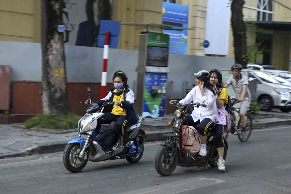 Nhiều người dân không đeo khẩu trang khi tham gia giao thông. (Ảnh: Tuấn Đức/TTXVN)
