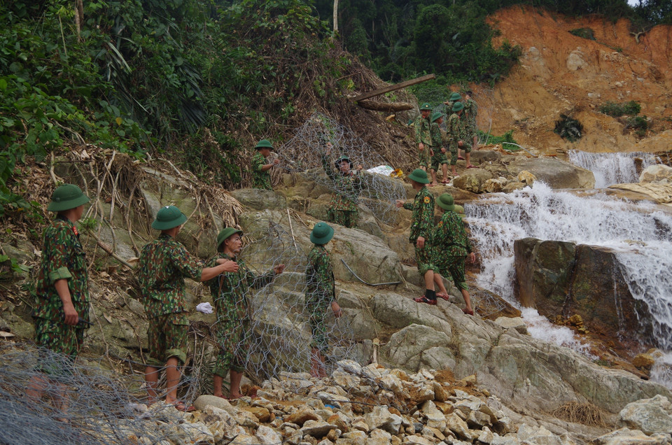 Lực lượng cứu hộ vận chuyển rọ đá để thực hiện nhiệm vụ nắn dòng suối Rào Trăng. (Ảnh: TTXVN phát)