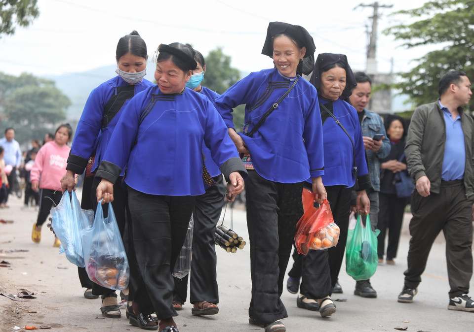 Khi ra về, ai ai cũng vui vẻ cùng với những món hàng hóa mua được ở phiên chợ. (Ảnh: Danh Lam/TTXVN)