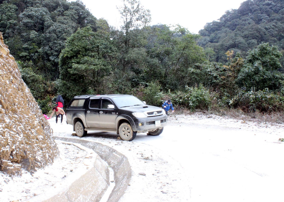 Một chiếc xe bán tải 2 cầu bị kẹt giữa dốc vì đường quá trơn. (Ảnh: Quốc Đạt/TTXVN)