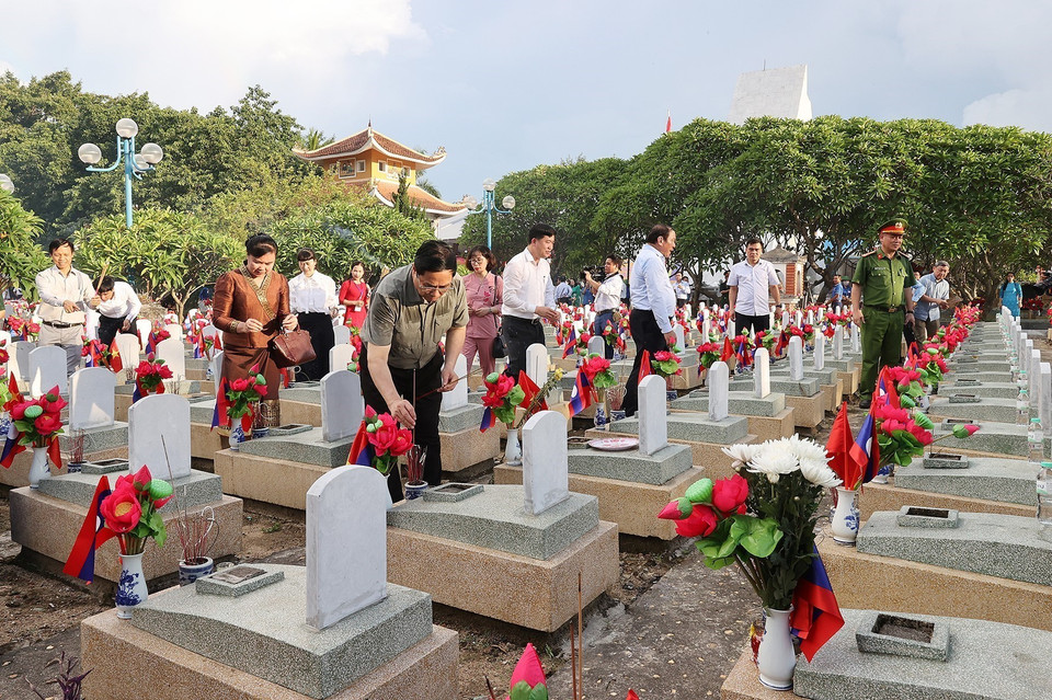 Thủ tướng Phạm Minh Chính thắp hương trên phần mộ liệt sỹ tại Nghĩa trang liệt sỹ quốc tế Việt - Lào. (Ảnh: Dương Giang/TTXVN)