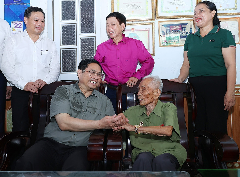 Thủ tướng Phạm Minh Chính thăm ông Bùi Đôn, cán bộ đảng viên 75 năm tuổi Đảng ở xã Thạch Sơn, huyện Anh Sơn. (Ảnh: Dương Giang/TTXVN)