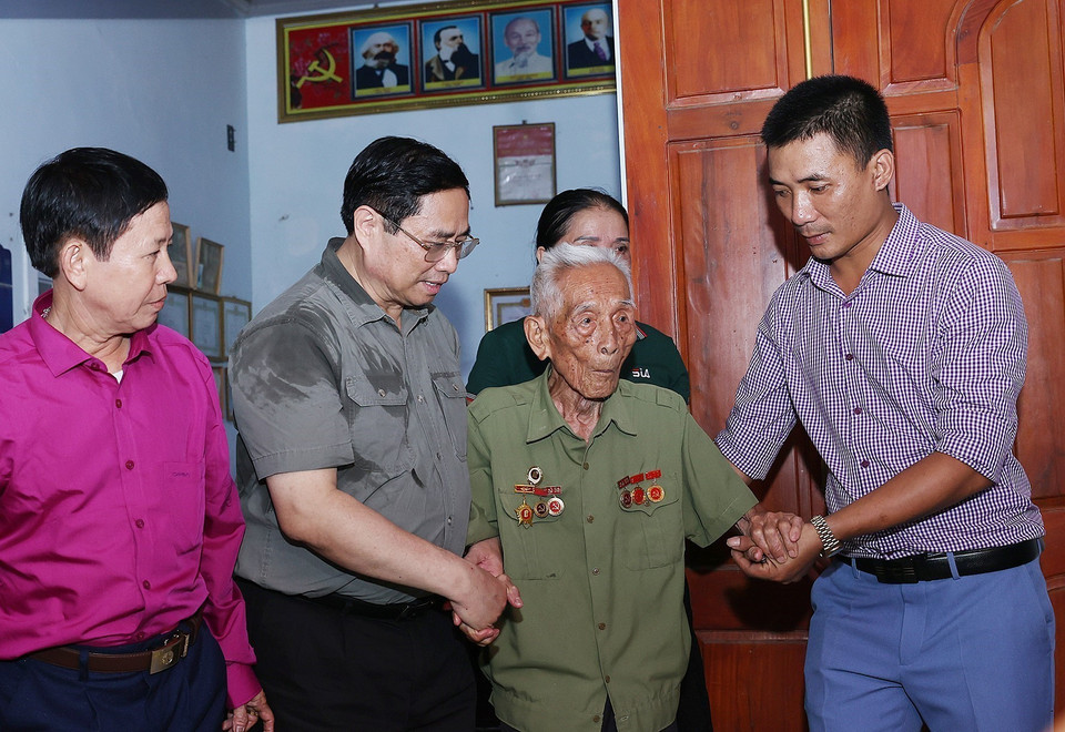 Thủ tướng Phạm Minh Chính thăm ông Bùi Đôn, cán bộ đảng viên 75 năm tuổi Đảng ở xã Thạch Sơn, huyện Anh Sơn. (Ảnh: Dương Giang/TTXVN)