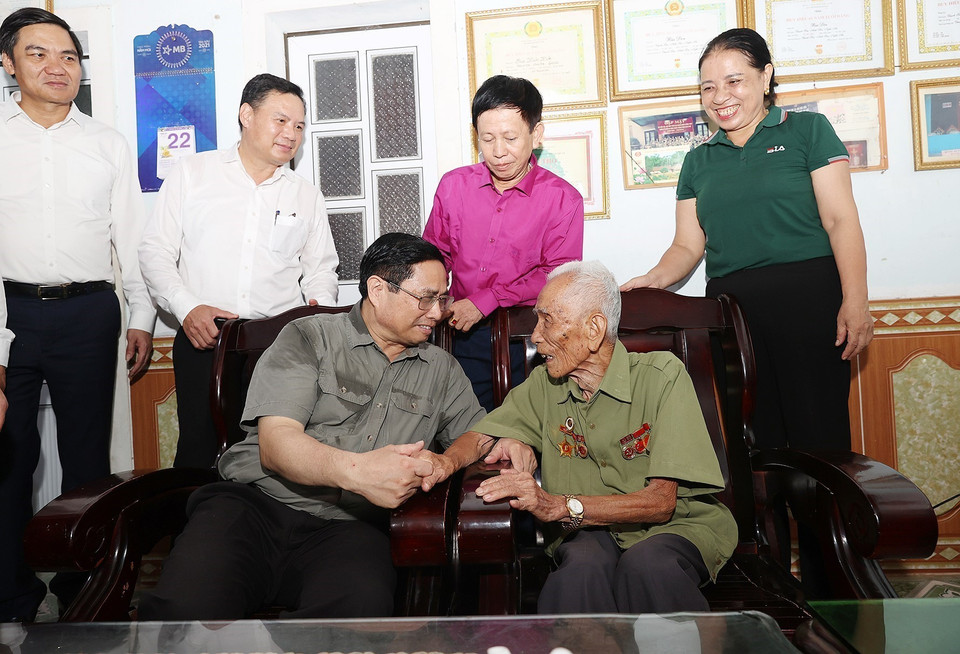 Thủ tướng Phạm Minh Chính thăm ông Bùi Đôn, cán bộ đảng viên 75 năm tuổi Đảng ở xã Thạch Sơn, huyện Anh Sơn. (Ảnh: Dương Giang/TTXVN)