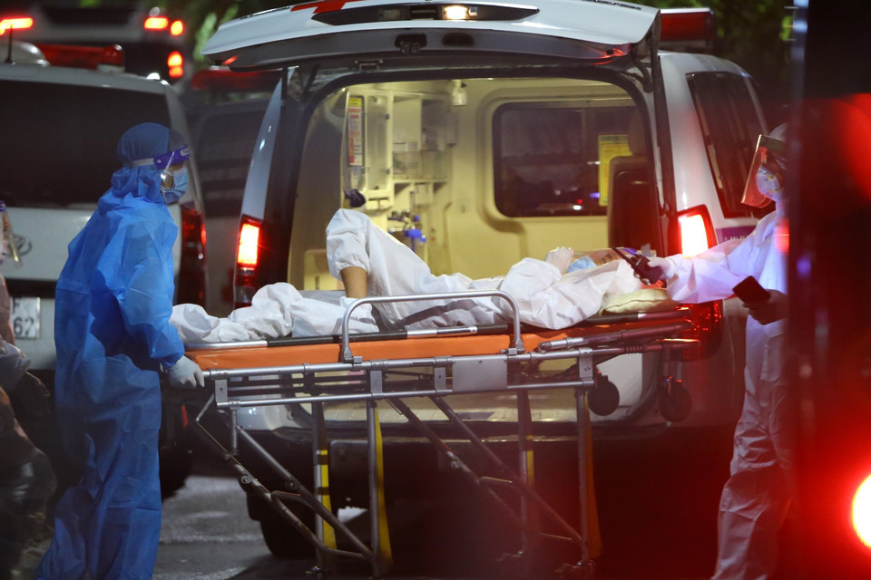 Một bệnh nhân nặng được di chuyển bằng cánh xuống từ xe cứu thương (chụp tại Bệnh viện Thanh Nhàn đêm 4/10). (Ảnh: Hoàng Hiếu/TTXVN)