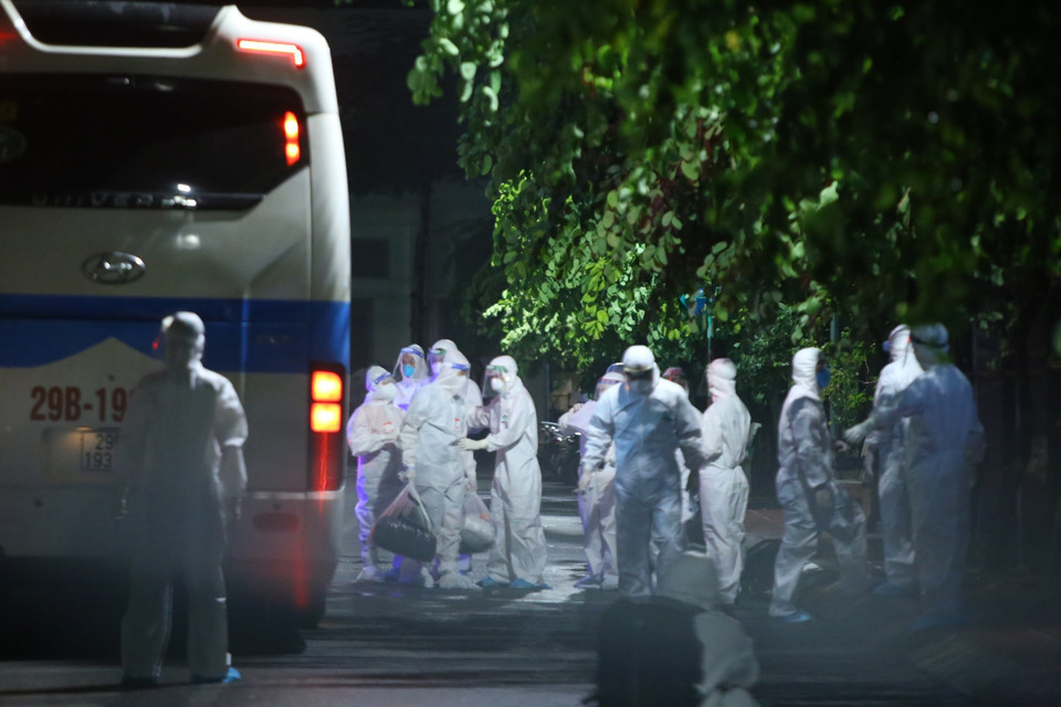 Các bệnh nhân và người nhà bệnh nhân xuống xe tại khu vực biệt lập tại Bệnh viện Thanh Nhàn. (Ảnh: Hoàng Hiếu/TTXVN)