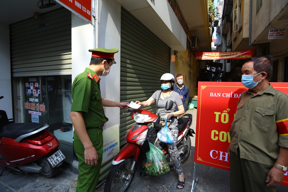 Lực lượng công an phối hợp với Tổ phòng, chống COVID cộng đồng phường Cầu Dền, quận Hai Bà Trưng kiểm tra giấy tờ người dân (ảnh chụp sáng 3/8/2021). (Ảnh: Hoàng Hiếu/TTXVN)