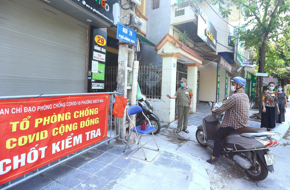 Tổ phòng, chống COVID cộng đồng thuộc tổ dân phố số 5, phường Bạch Mai, quận Hai Bà Trưng kiểm soát người dân ra, vào ngõ 29 Hồng Mai (ảnh chụp sáng 3/8). (Ảnh: Hoàng Hiếu/TTXVN)