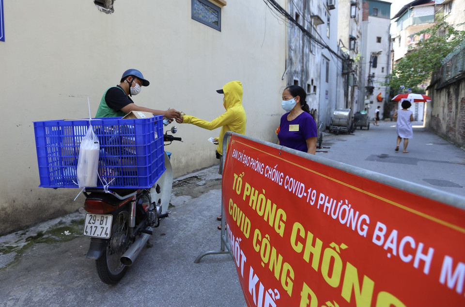 Nhiệm vụ của các Tổ phòng, chống COVID cộng đồng là đi từng ngõ, gõ từng nhà để rà soát các trường hợp trở về từ vùng dịch và nhắc nhở người dân ý thức chấp hành thông điệp 5K, hàng quán tuân thủ nghiêm quy định đóng cửa. (Ảnh: Hoàng Hiếu/TTXVN)