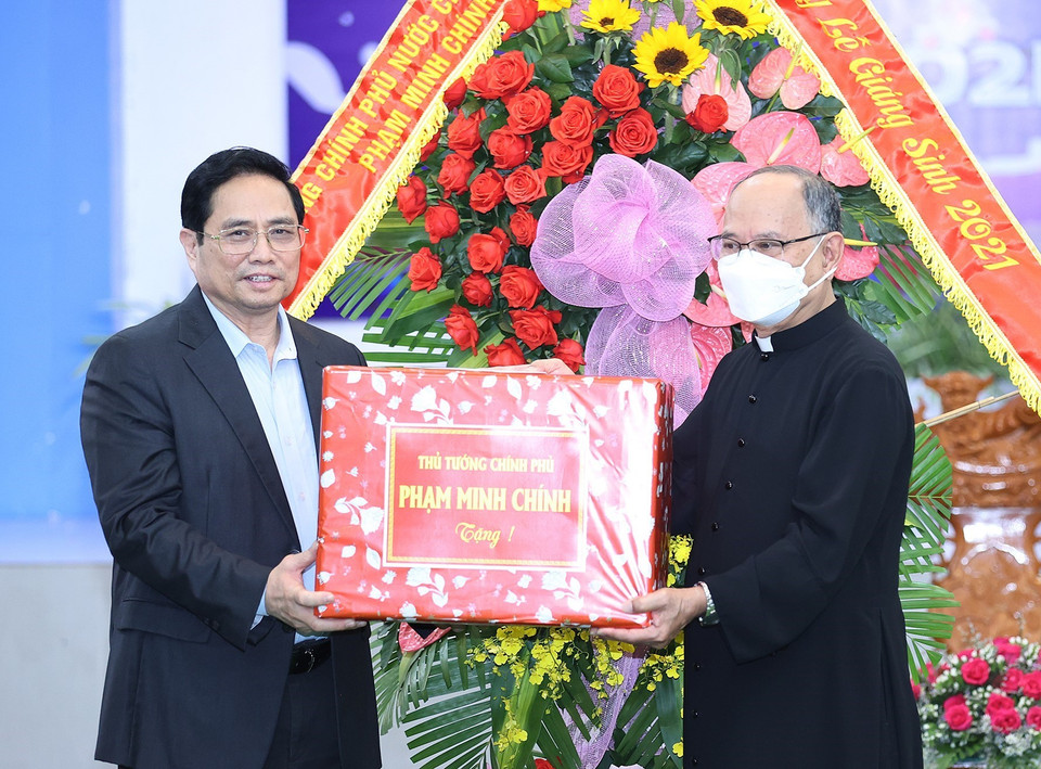 Thủ tướng Phạm Minh Chính tặng quà chúc mừng giáng sinh giáo dân giáo xứ Long Hương. (Ảnh: Dương Giang/TTXVN)