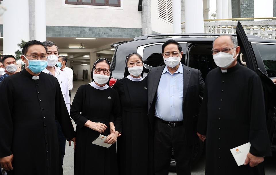 Thủ tướng Phạm Minh Chính thăm hỏi các giáo dân giáo xứ Long Hương nhân dịp Lễ Giáng sinh 2021. (Ảnh: Dương Giang/TTXVN)