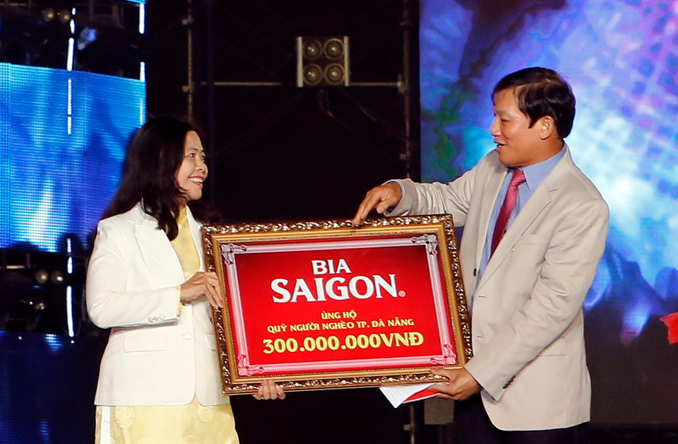 Đại diện Công ty Bia Sài Gòn trao bảng tượng trưng số tiền ủng hộ cho Quỹ người nghèo Đà Nẵng. (Ảnh: Trần Lê Lâm/Vietnam+)