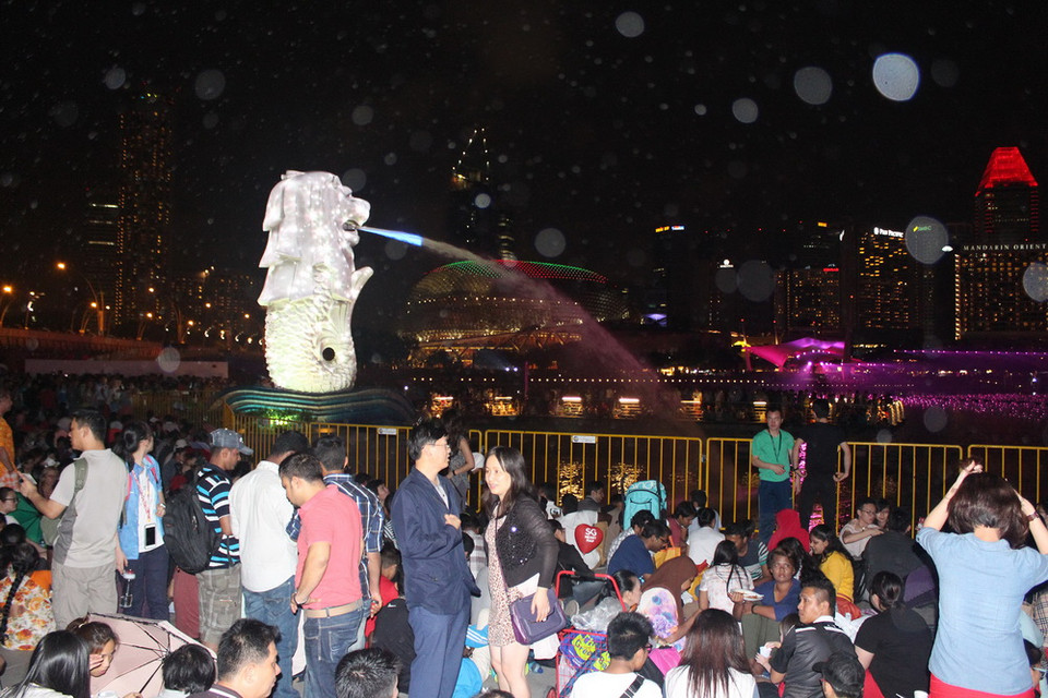 Ngay từ tối, nhiều người đã tập trung xung quanh khu vực Marina để chờ đón màn bắn pháo hoa chào mừng Năm mới 2015. (Ảnh: Lê Hải-Việt Hải/Vietnam+)