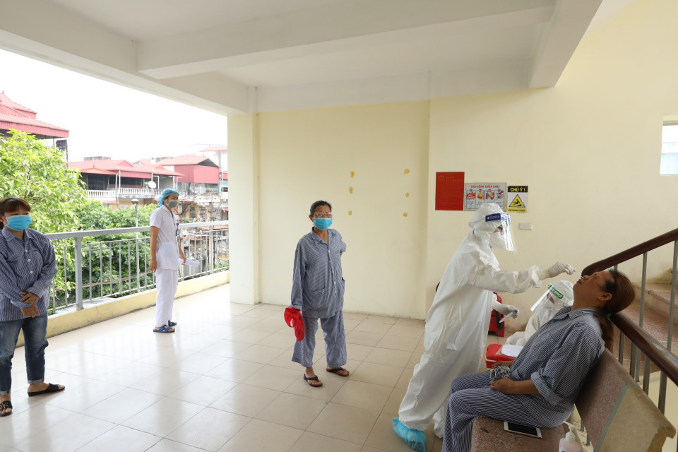 Nhân viên y tế lấy mẫu xét nghiệm COVID-19 cho bệnh nhân, người nhà tại các khoa, phòng. (Ảnh: Minh Quyết/TTXVN)