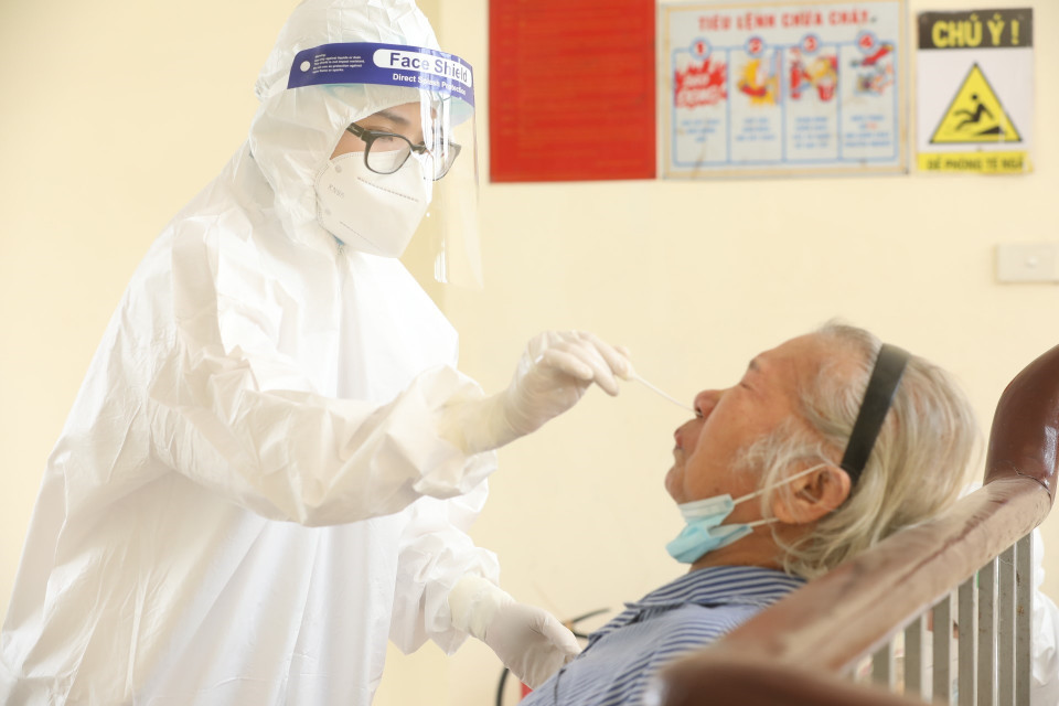 Nhân viên y tế lấy mẫu xét nghiệm COVID-19 cho bệnh nhân, người nhà tại các khoa, phòng. (Ảnh: Minh Quyết/TTXVN)