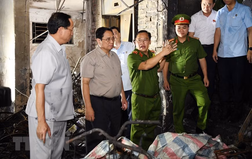 Thủ tướng Phạm Minh Chính kiểm tra hiện trường vụ cháy Chung cư mini ở phố Khương Hạ (Thanh Xuân, Hà Nội). (Ảnh: Dương Giang/TTXVN)