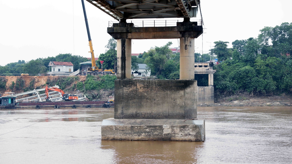 Mặt cầu nhịp số 5 (N5) đã bị nghiêng ra ngoài phía lòng sông Hồng (có dấu hiệu trụ T6 bị sụt lún). (Ảnh: Tạ Toàn/TTXVN)