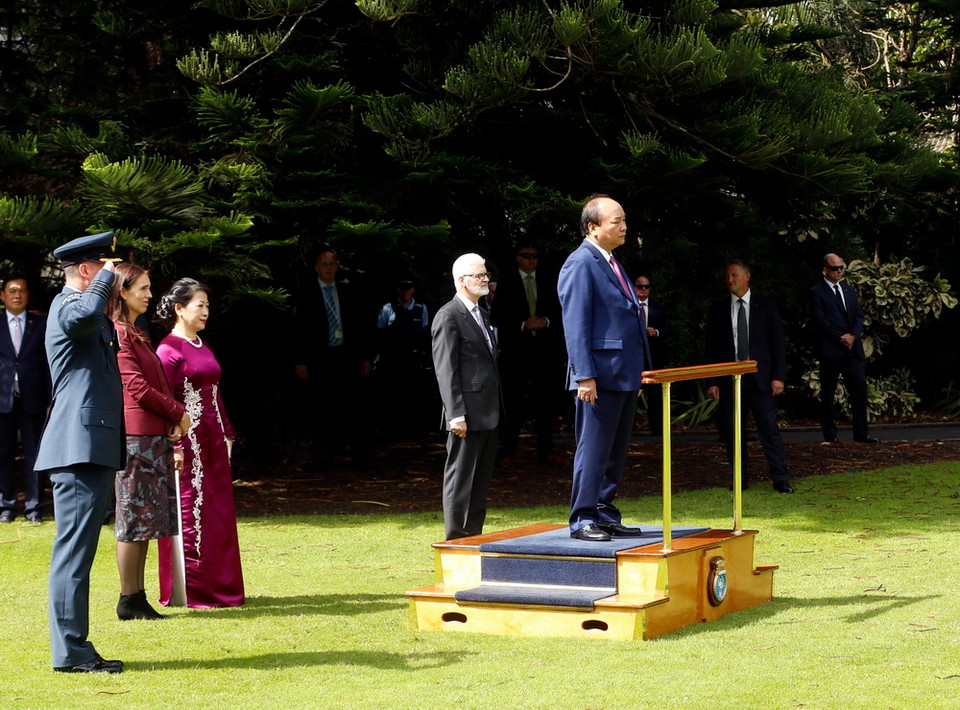 Thủ tướng Nguyễn Xuân Phúc trên bục danh dự thực hiện nghi thức chào cờ tại lễ đón. (Ảnh: Thống Nhất/TTXVN)