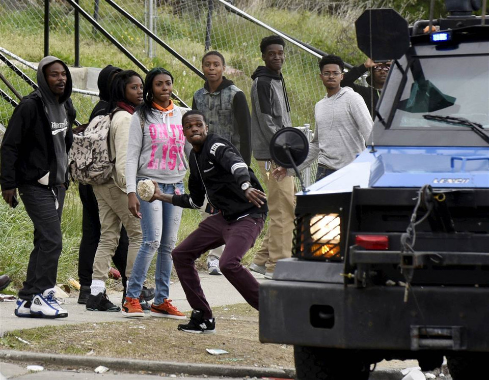 Một người dân ném đá về phía cảnh sát. (Nguồn: Reuters)