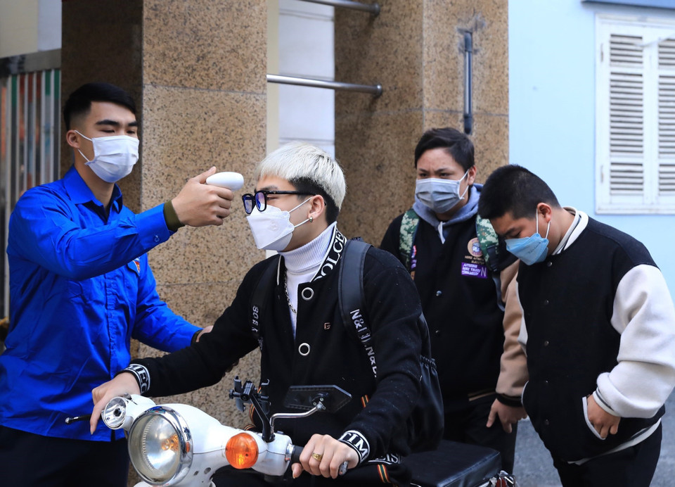 Đo thân nhiệt tất cả học sinh, sinh viên và giáo viên trước khi vào Trường Cao đẳng cơ điện Hà Nội. (Ảnh: Hoàng Hiếu/TTXVN)