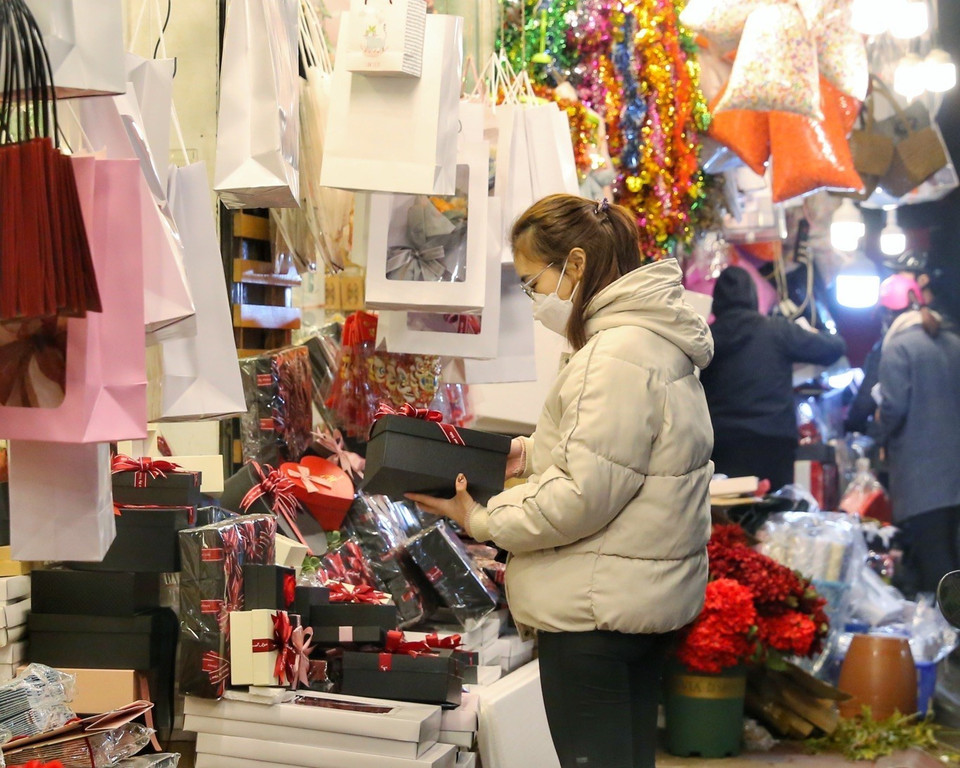 Các bạn trẻ đi mua những món quà cho "nửa kia" của mình. (Ảnh: Tuấn Đức/TTXVN)