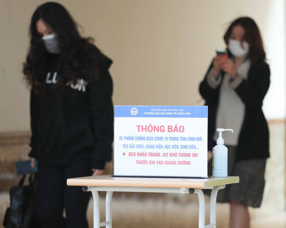 Sinh viên trường Đại học Kinh tế Quốc dân tới trường học trực tiếp, thực hiện tốt công tác phòng, chống dịch. (Ảnh: Thanh Tùng/TTXVN)