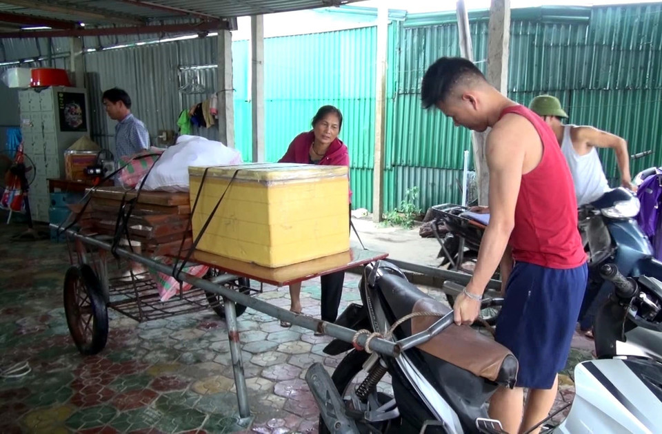 Các chủ kinh doanh tại bãi biển Cửa Hội dùng bao cát gia cố kiốt trước cơn bão số 3. (Ảnh: Tá Chuyên/TTXVN)