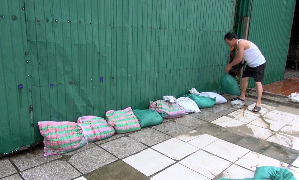 Các chủ kinh doanh tại bãi biển Cửa Hội chuẩn bị bao cát để gia cố kiốt trước cơn bão số 3. (Ảnh: Tá Chuyên/TTXVN)