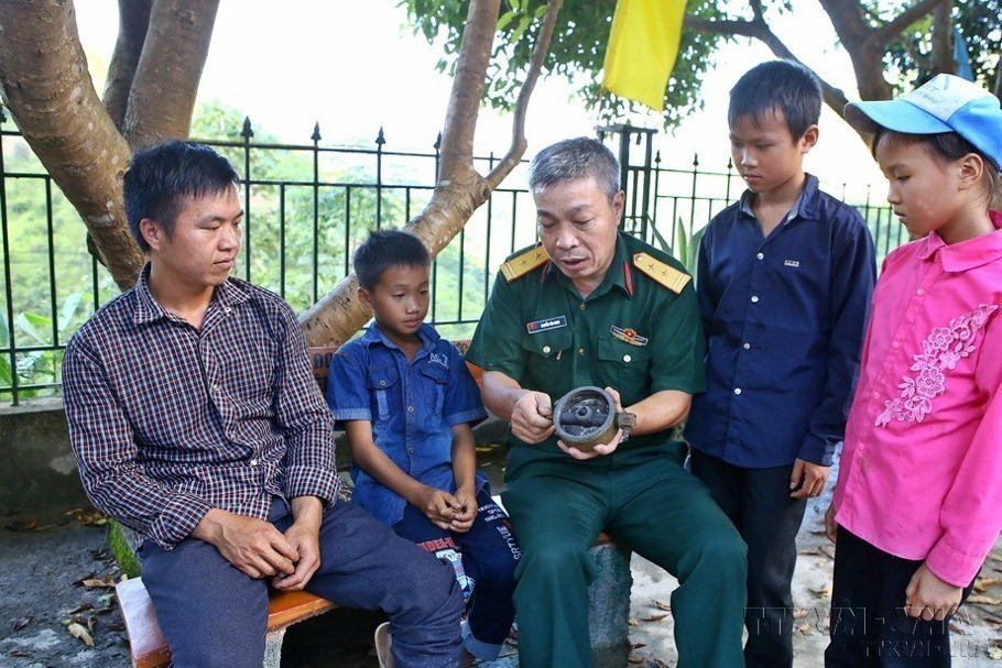 Trung tá Nguyễn Văn Minh, Trưởng Ban Công binh (Bộ Chỉ huy Quân sự Hà Giang) chia sẻ về tác hại và ảnh hưởng của bom, mìn, vật nổ với đồng bào, giúp người dân Hà Giang nâng cao ý thức phòng, tránh, đảm bảo an toàn tính mạng và tài sản, tạo điều kiện thuận lợi cho nhân dân vùng biên giới có đất canh tác. (Ảnh: Minh Quyết/TTXVN)