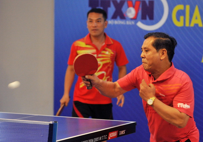 Ông Tô Quang Phán và Nguyễn Ngọc Hải (Báo Hà Nội Mới) thi đấu nội dung đôi nam. (Ảnh: Quốc Khánh/TTXVN) 