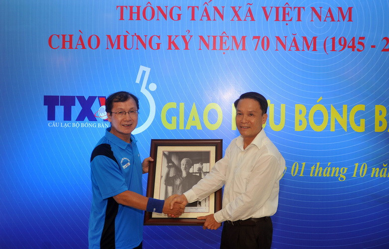 Ông Nguyễn Đức Lợi​ - Bí thư Đảng ủy, Tổng Giám đốc Thông tấn xã Việt Nam tặng bức ảnh Bác Hồ tập luyện Thể dục thể thao cho CLB Bóng bàn TTXVN. (Ảnh: Quốc Khánh/TTXVN) 