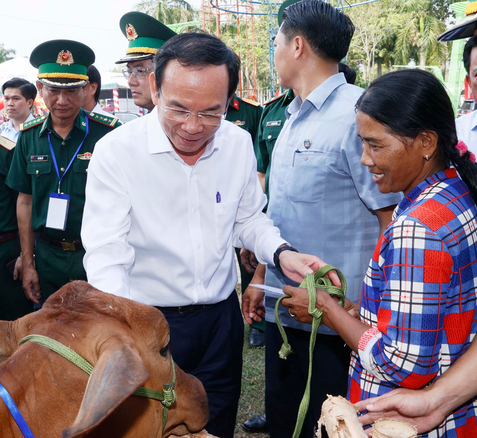 Bí thư Thành ủy TP. Hồ Chí Minh Nguyễn Văn Nên tặng bò cho hộ nghèo. (Ảnh: Thống Nhất/TTXVN)