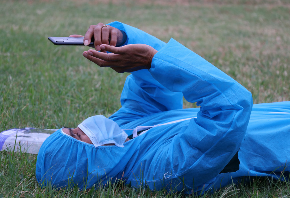 Phút nghỉ ngơi sau khoảng thời gian chạy xe xuyên đêm đưa công dân về quê của tài xế xe Phương Trang. (Ảnh: Phạm Cường/TTXVN)