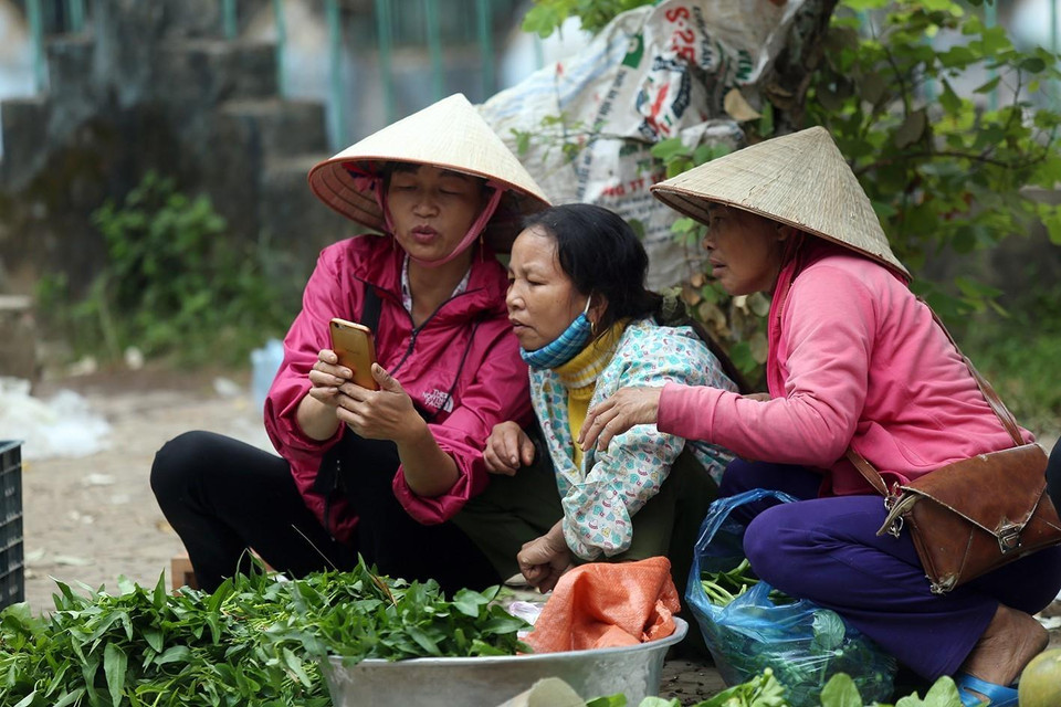 Phụ nữ vùng cao tranh thủ bán những mớ rau, con cá để có thêm thu nhập. (Ảnh: Phan Tuấn Anh/TTXVN)