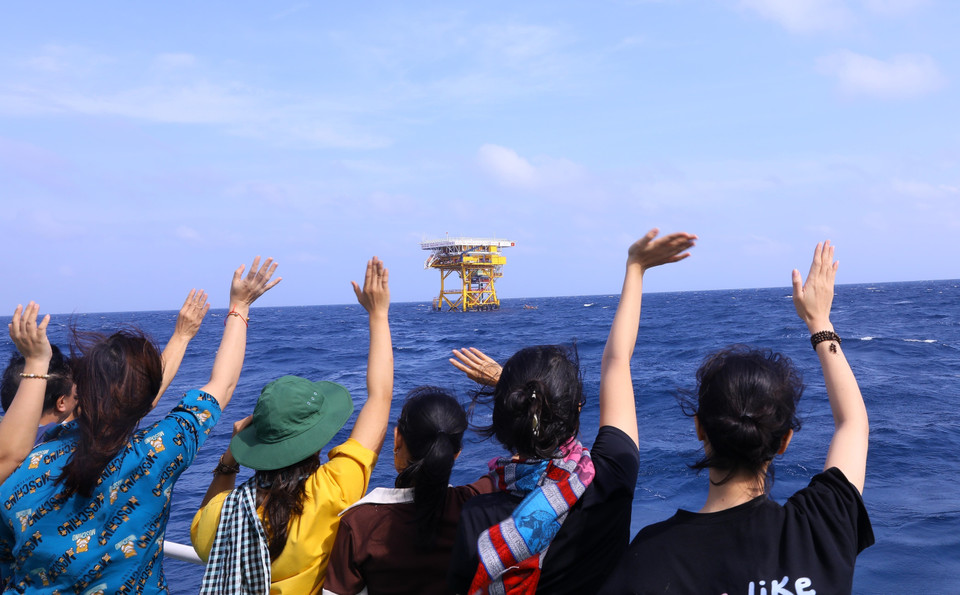 Thành viên đoàn công tác vẫy tay chào cán bộ, chiến sỹ Nhà giàn DK1 trước khi về đất liền. (Ảnh: Văn Điệp/TTXVN)